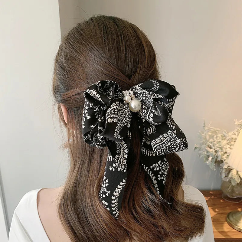 Woman with hair styled with a decorative black and white bow accessory.