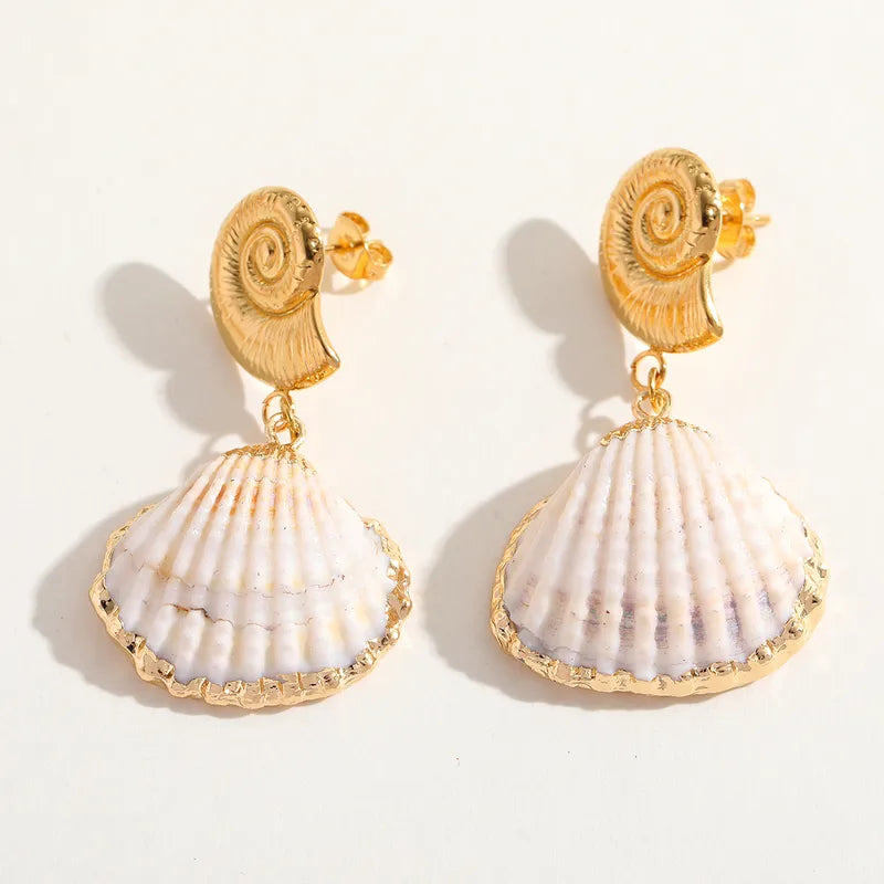 Shell-shaped earrings with gold accents on a white background