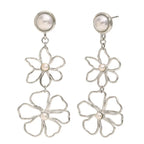 Silver flower-shaped earrings with pearl centers on a white background