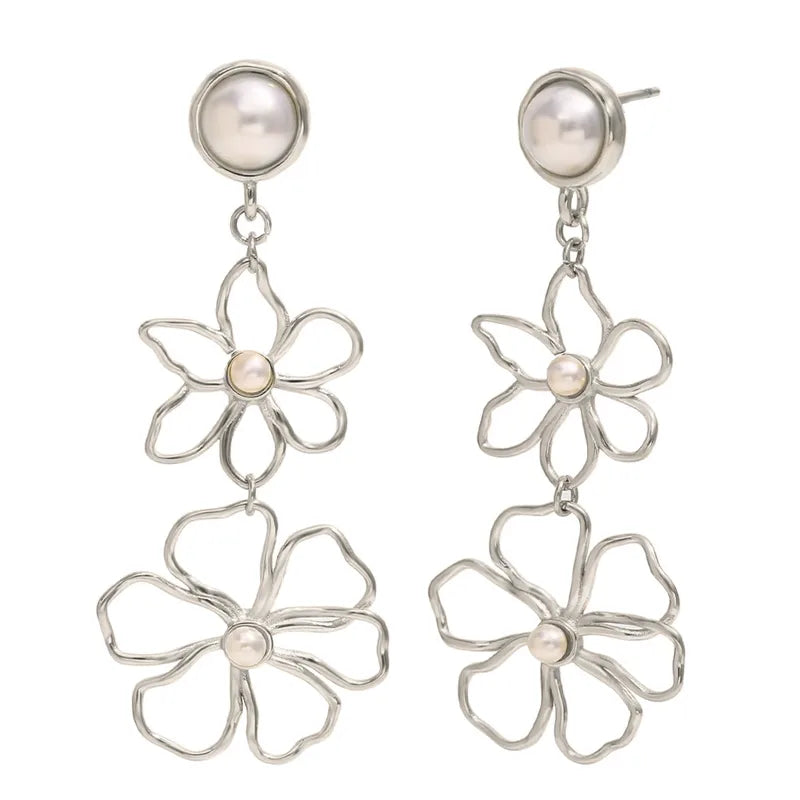 Silver flower-shaped earrings with pearl centers on a white background