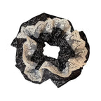 Black scrunchie with lace detailing on a white background