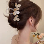 Woman with a stylish hair bun adorned with decorative flowers, wearing earrings.