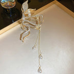 Gold leaf-shaped clip with pearl drops on a white surface