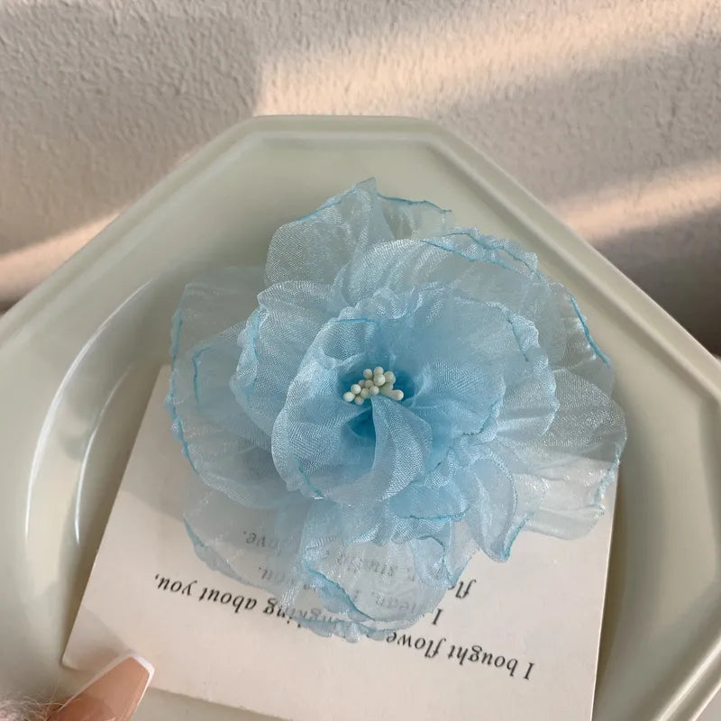 Blue floral hair clip on a white card with text