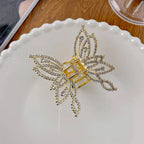 Gold butterfly-shaped hair clip with rhinestones on a white plate