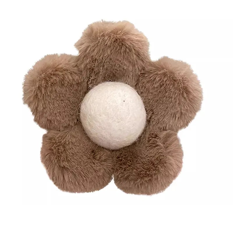 Floral-shaped plush clip with brown petals and a white center on a white background