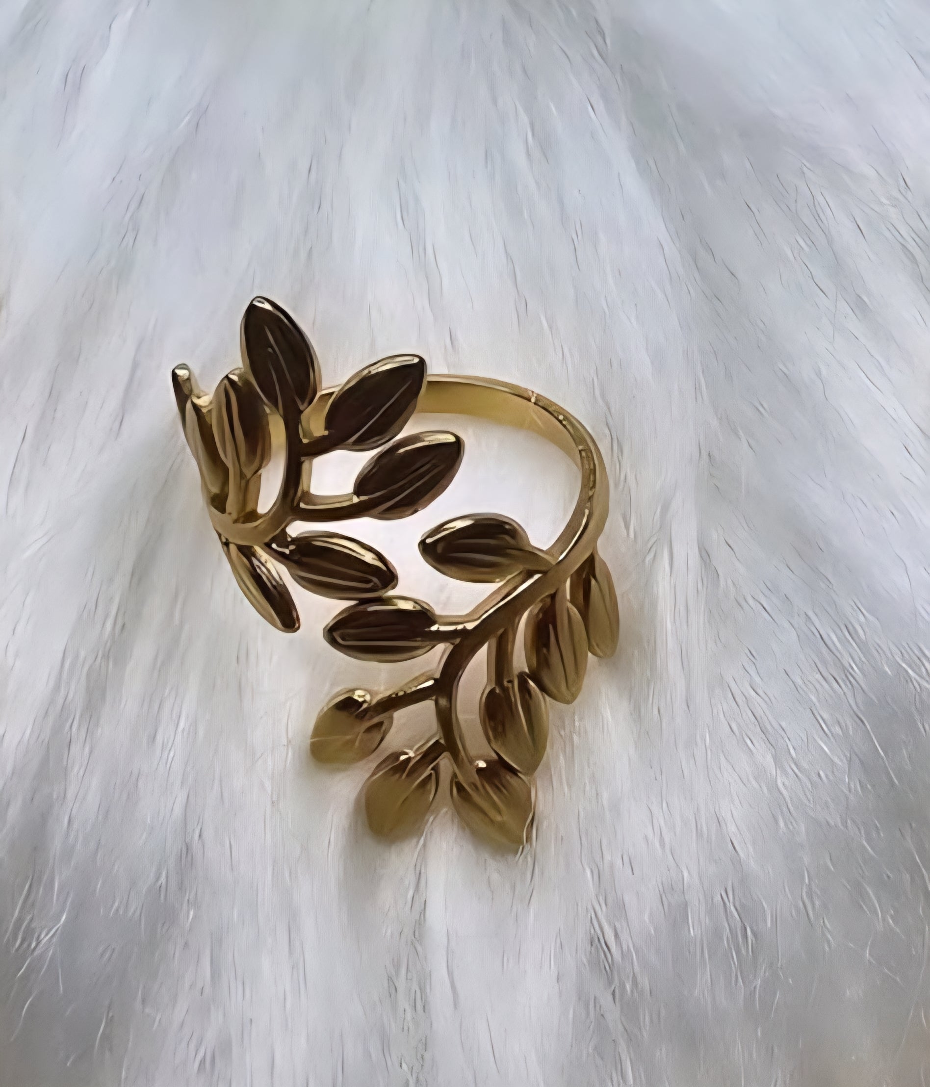 Gold leaf shaped cuff bracelet on a white fur background