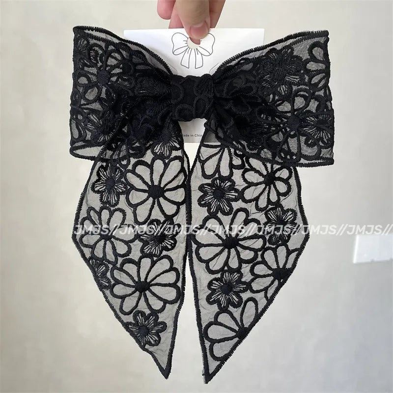 Black lace bow with floral patterns on a white background