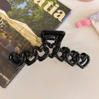 Black chain-like hair clip on a magazine background