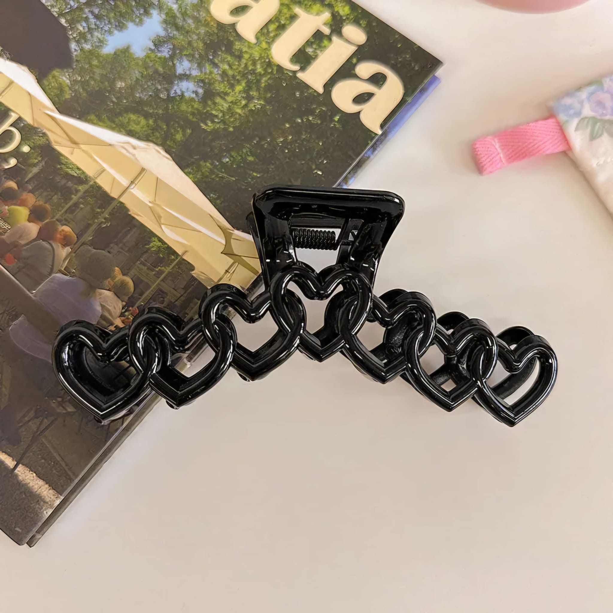 Black chain-like hair clip on a magazine background