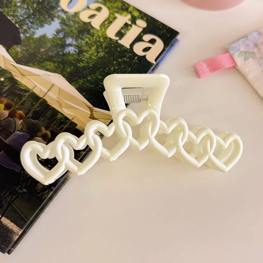Neon light shaped like a cross with heart designs on a magazine background