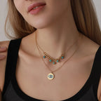 Close-up of a woman wearing a gold necklace with turquoise beads and an eye pendant.
