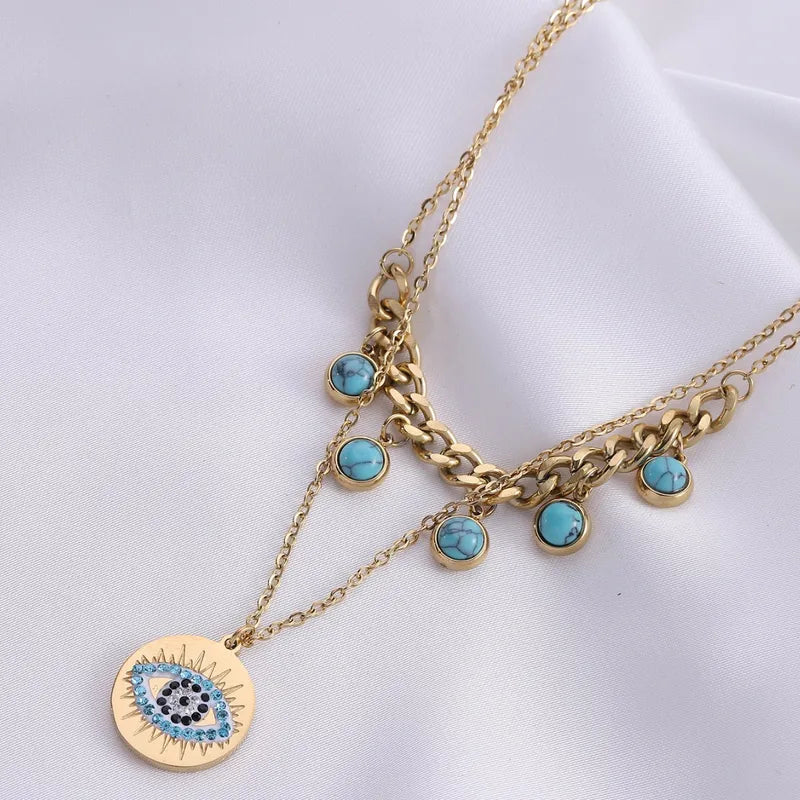 Gold necklace with turquoise charms on a white background