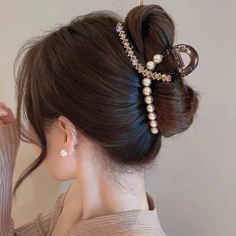 Woman with a stylish hair bun adorned with decorative hair clip on a neutral background