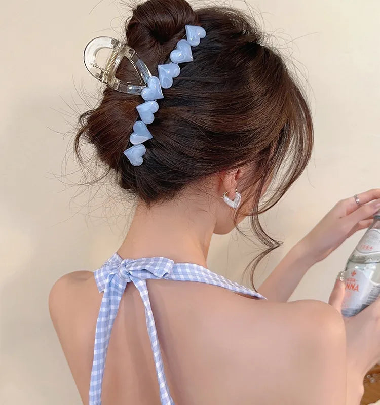 Woman with a stylish hair accessory and a checkered dress, holding a can.